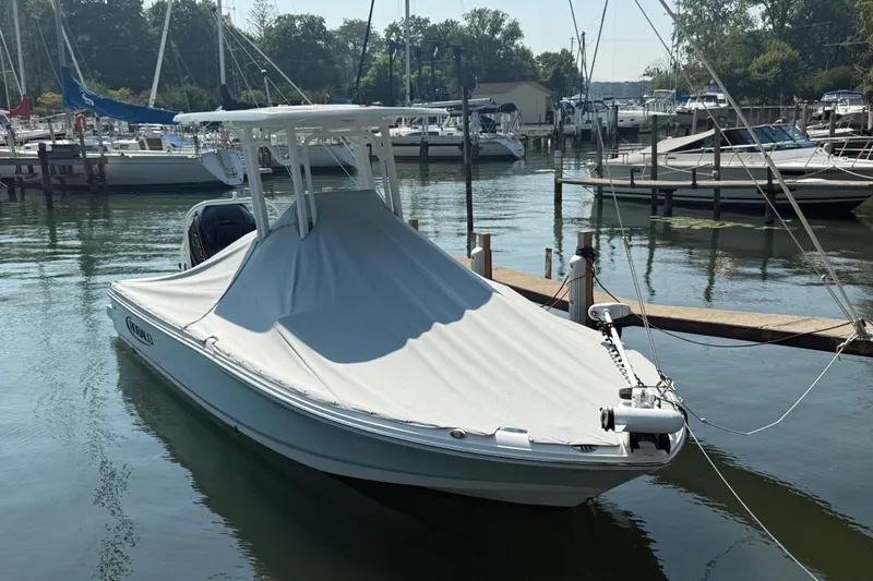 Slide: The Image of 2022 Robalo 226 Cayman boat covered and docked in a marina. - 27