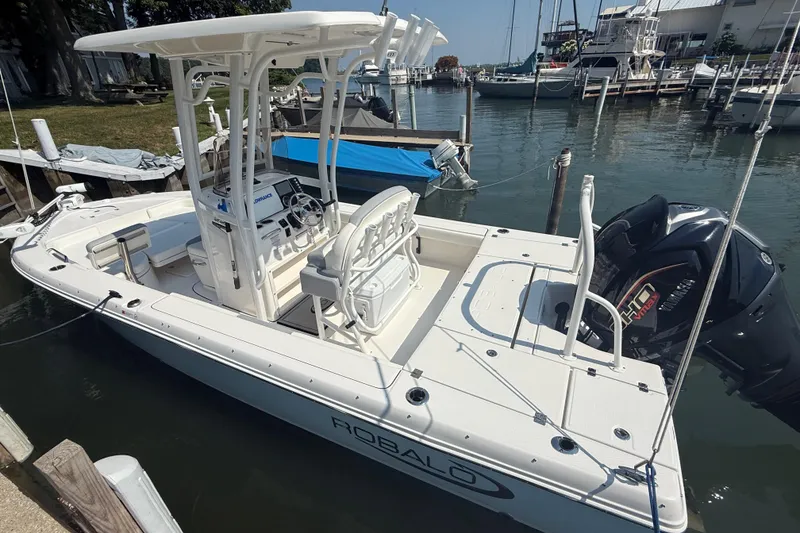 Slide: The Image of 2022 Robalo 226 Cayman boat docked at marina, featuring center console and outboard motor. - 4