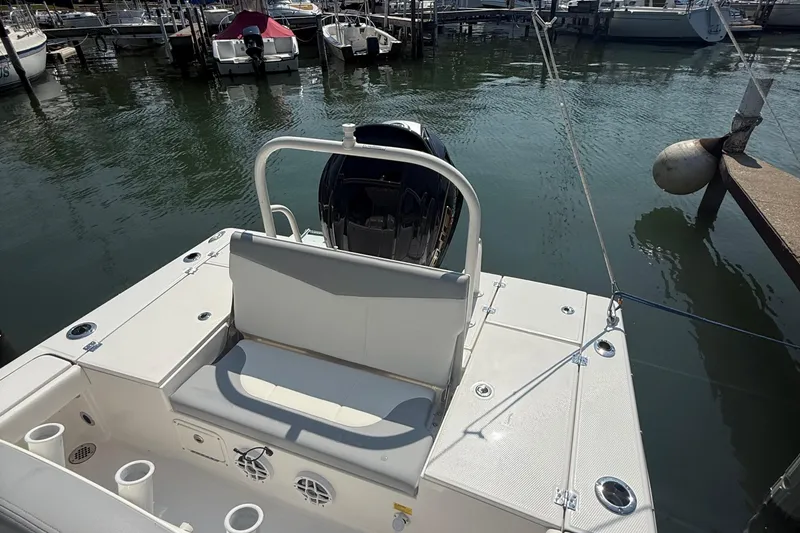 Slide: The Image of 2022 Robalo 226 Cayman boat docked at marina, featuring spacious seating and outboard motor. - 8