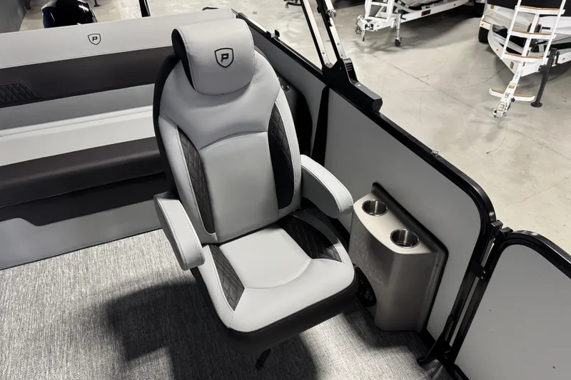 Slide: The Image of 2026 Premier 210 Sunsation RL boat interior with gray captain's chair and cup holders. - 9