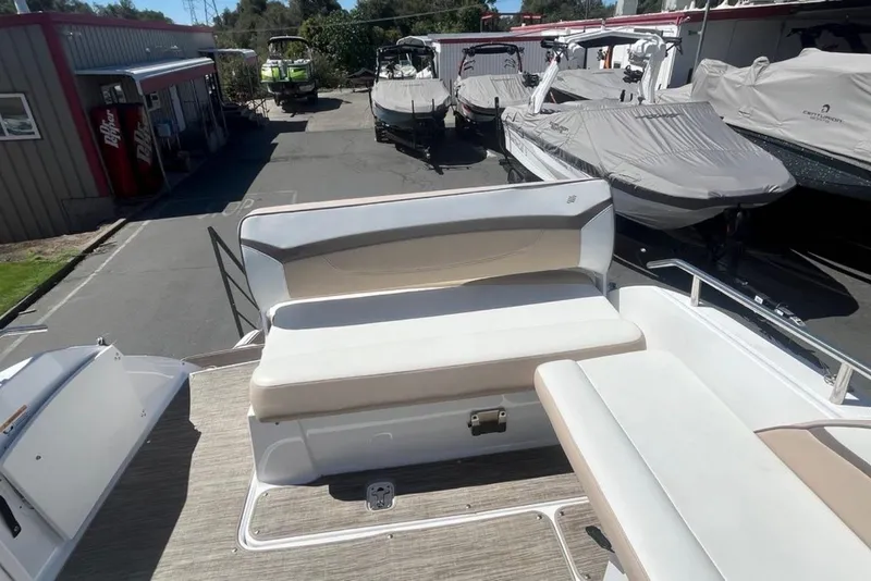Slide: The Image of 2020 Four Winns V255 boat with white seating, parked in a marina. - 11