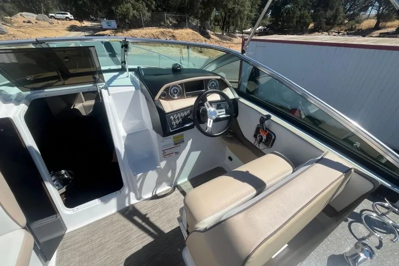 Slide: The Image of 2020 Four Winns V255 boat interior with steering wheel and seating area. - 14