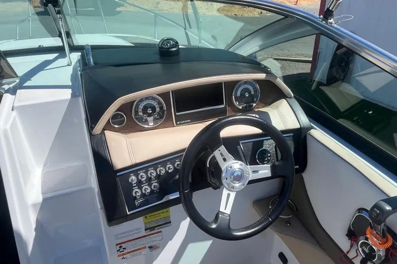 Slide: The Image of 2020 Four Winns V255 boat dashboard with steering wheel and control panel. - 15