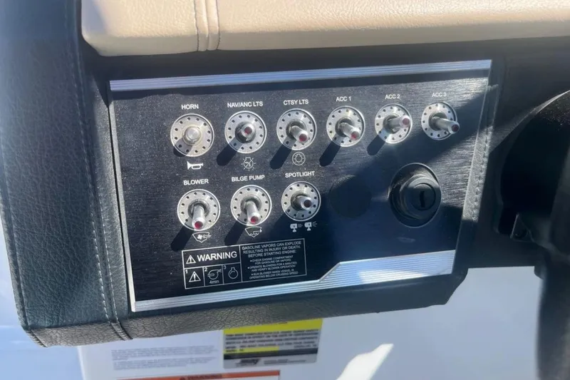 Slide: The Image of Control panel of 2020 Four Winns V255 boat with various switches and warning labels. - 16