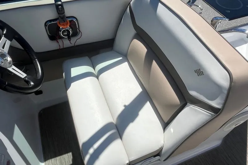 Slide: The Image of 2020 Four Winns V255 boat interior with steering wheel and cushioned seating. - 19