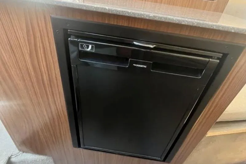 Slide: The Image of Compact black refrigerator in 2020 Four Winns V255 boat interior. - 24