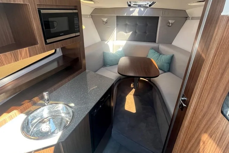 Slide: The Image of 2020 Four Winns V255 cabin interior with kitchenette, seating area, and modern design. - 30