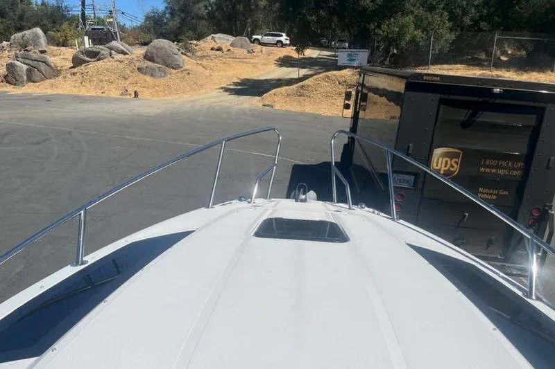 Slide: The Image of 2020 Four Winns V255 boat on trailer near UPS truck in parking area. - 31