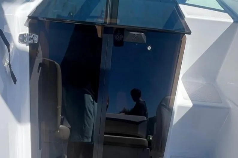 Slide: The Image of 2020 Four Winns V255 boat cabin entrance with sleek glass doors. - 32