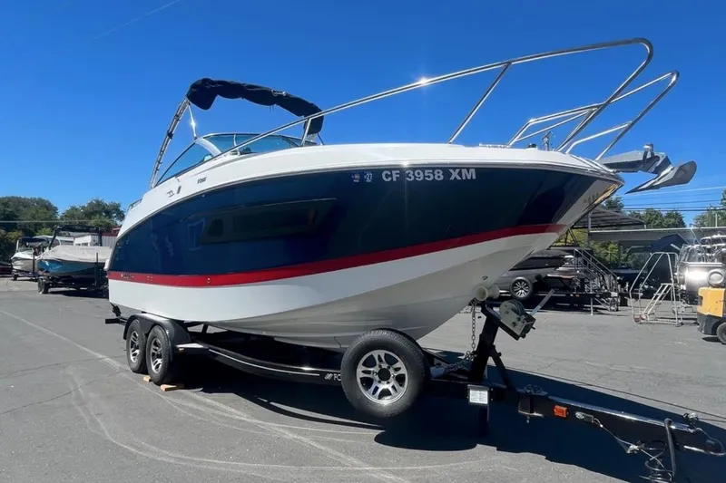 Slide: The Image of 2020 Four Winns V255 boat on trailer under clear blue sky. - 33