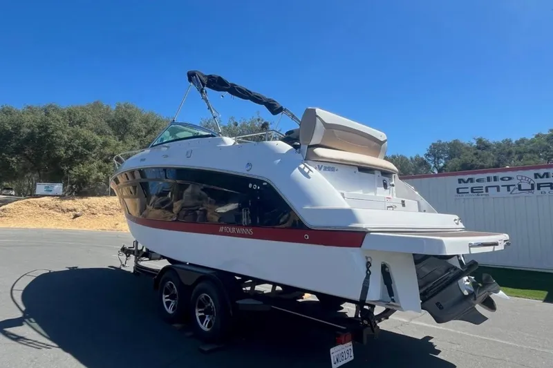 Slide: The Image of 2020 Four Winns V255 boat on trailer, parked outdoors under clear blue sky. - 36