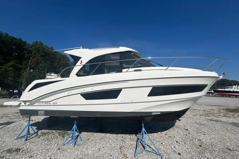 The Image of 2020 Beneteau Antares boat on stands, displayed outdoors under clear blue sky. - 0