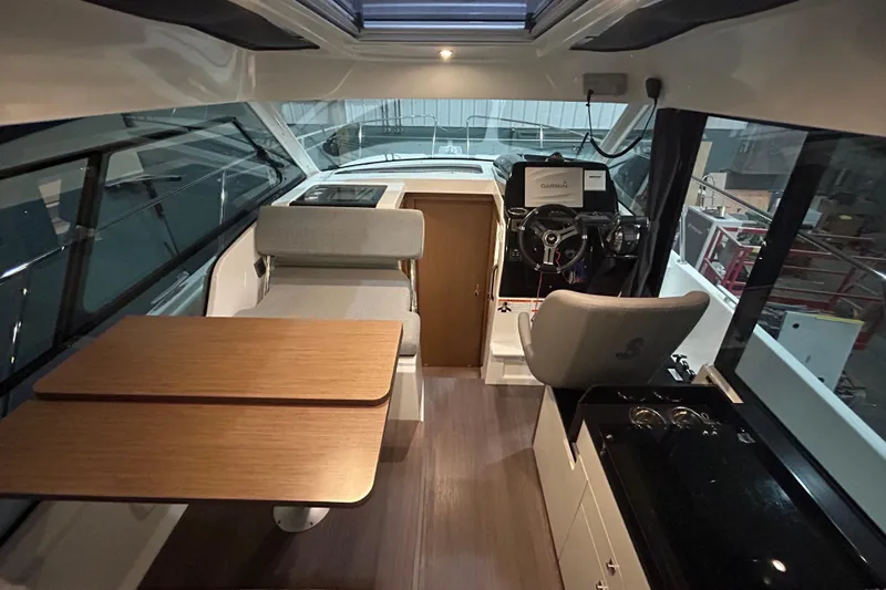 Slide: The Image of 2020 Beneteau Antares 9 boat with outdoor seating and wooden table. - 9