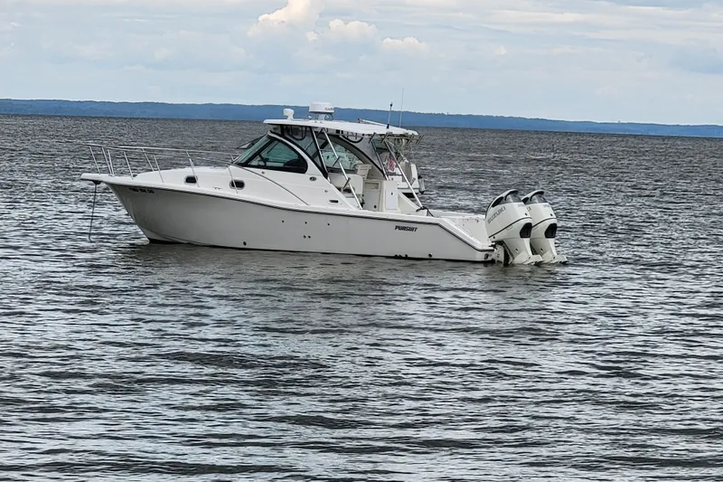 The Image of 2007 Pursuit OS 335 Offshore boat on calm water, featuring twin outboard engines. - 1