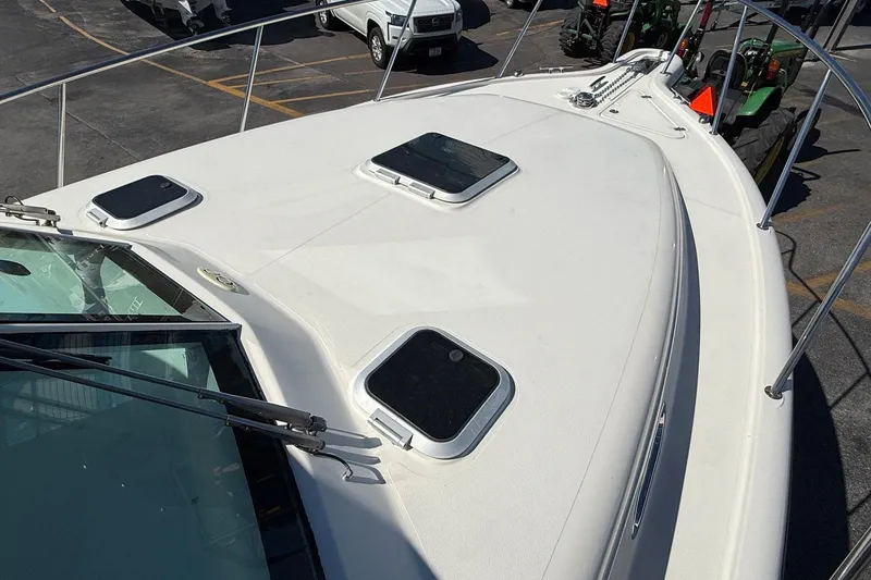 Slide: The Image of 2007 Pursuit OS 335 Offshore boat deck with hatches and railing in a parking area. - 5