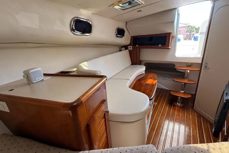Slide: The Image of 2007 Pursuit OS 335 Offshore cabin interior with wooden flooring and seating area. - 8