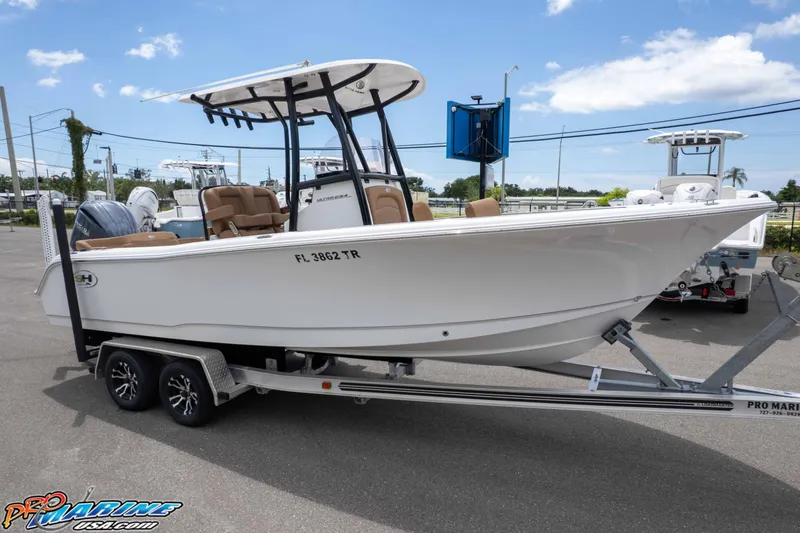 Slide: The Image of 2023 Sea Hunt Ultra 234 boat on trailer under clear blue sky. - 1
