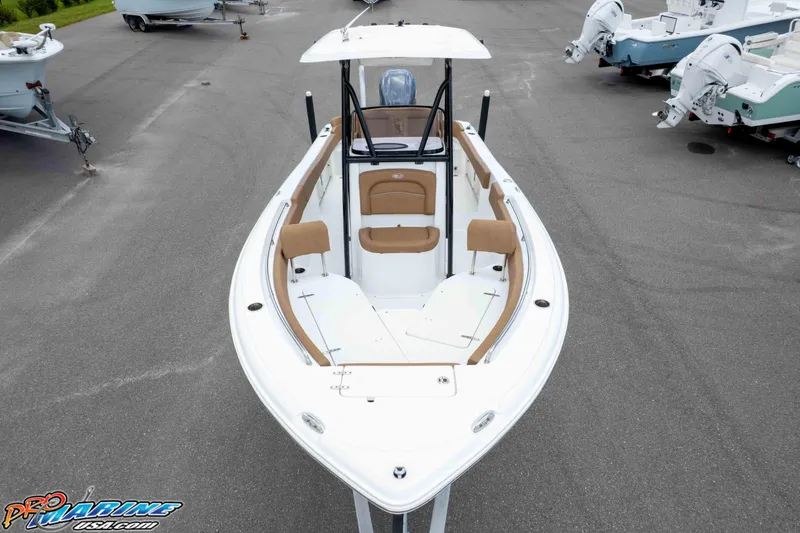 Slide: The Image of 2023 Sea Hunt Ultra 234 boat with tan seating, displayed in a marina. - 15