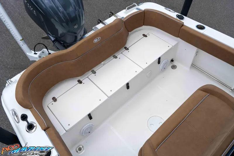 Slide: The Image of 2023 Sea Hunt Ultra 234 boat interior with brown seating and storage compartments. - 19