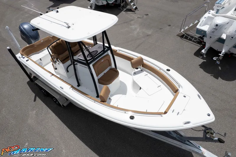 Slide: The Image of 2023 Sea Hunt Ultra 234 boat with white hull and tan seating, displayed on a trailer. - 2