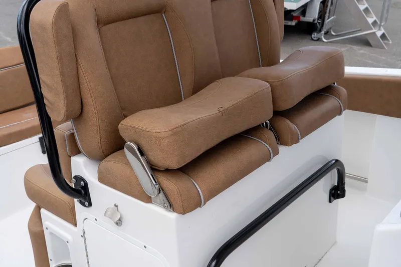 Slide: The Image of 2023 Sea Hunt Ultra 234 boat seat with brown upholstery and adjustable armrests. - 24