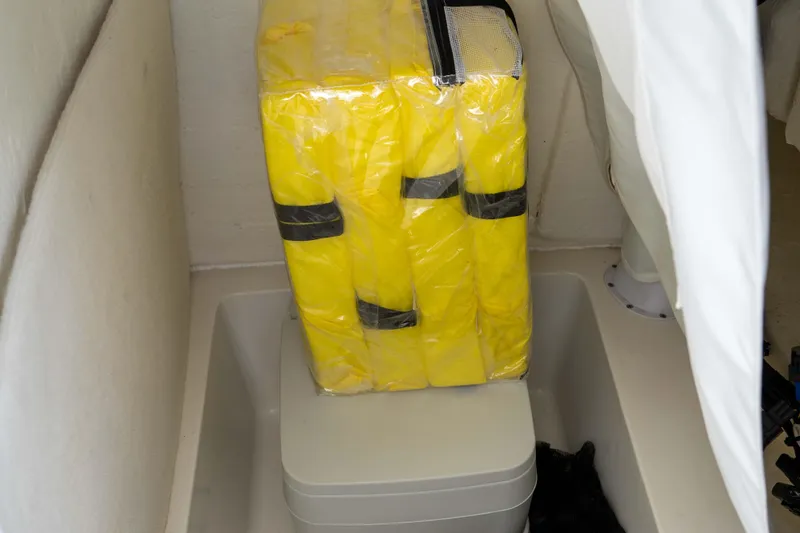 Slide: The Image of Yellow life jackets stored in a 2023 Sea Hunt Ultra 234 boat compartment. - 33