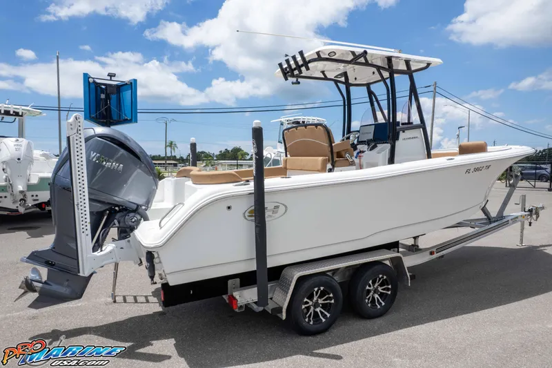 Slide: The Image of 2023 Sea Hunt Ultra 234 boat on trailer with Yamaha outboard motor, under clear sky. - 6