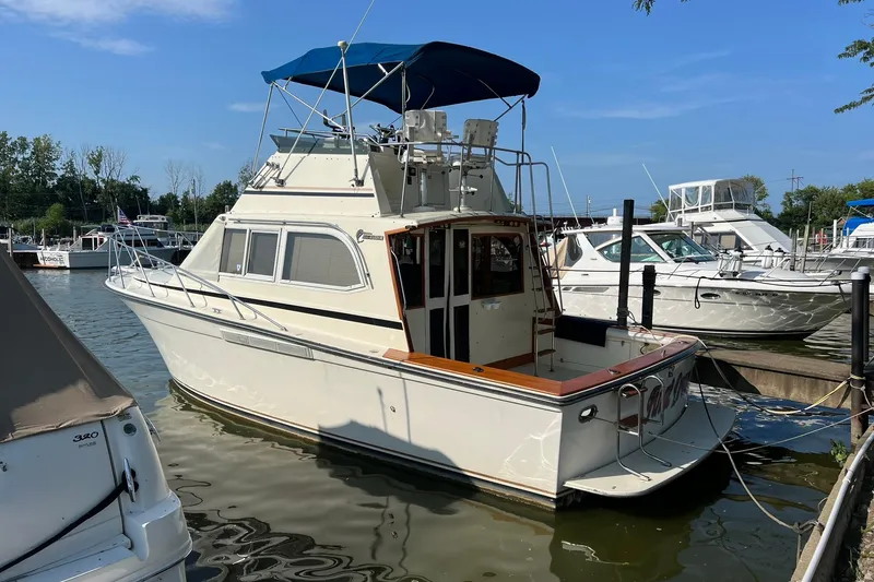 The Image of 1989 Egg Harbor 33 Convertible boat docked at marina under blue sky. - 0