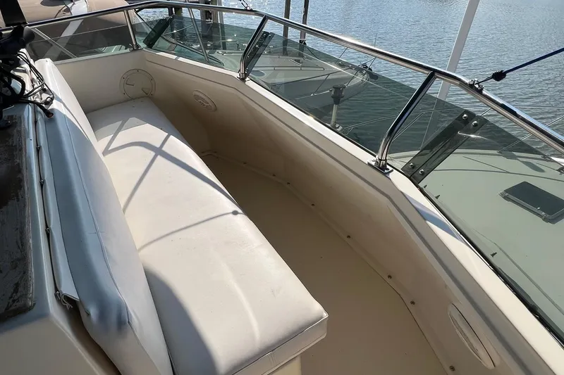 Slide: The Image of 1989 Egg Harbor 33 Convertible boat interior with white seating and glass railing. - 12