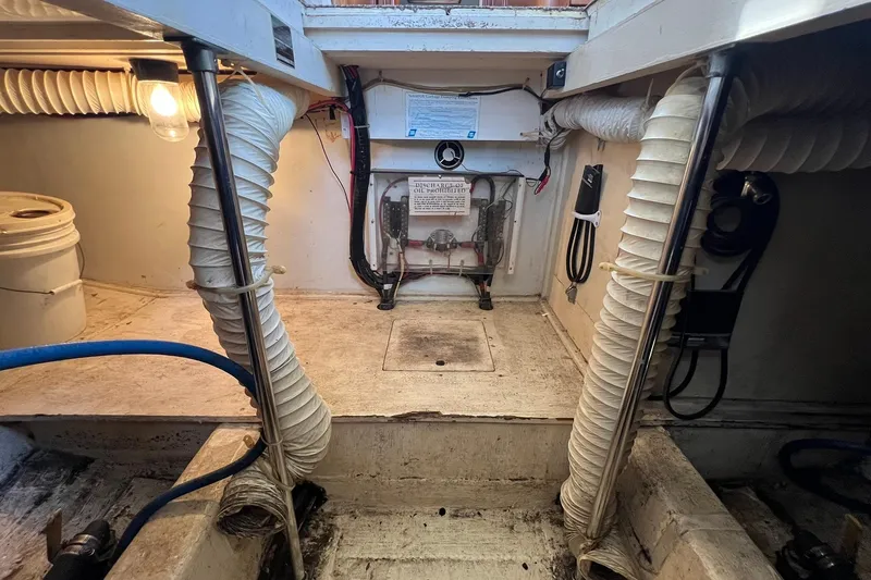 Slide: The Image of Engine room of 1989 Egg Harbor 33 Convertible boat, featuring ventilation ducts and equipment. - 25