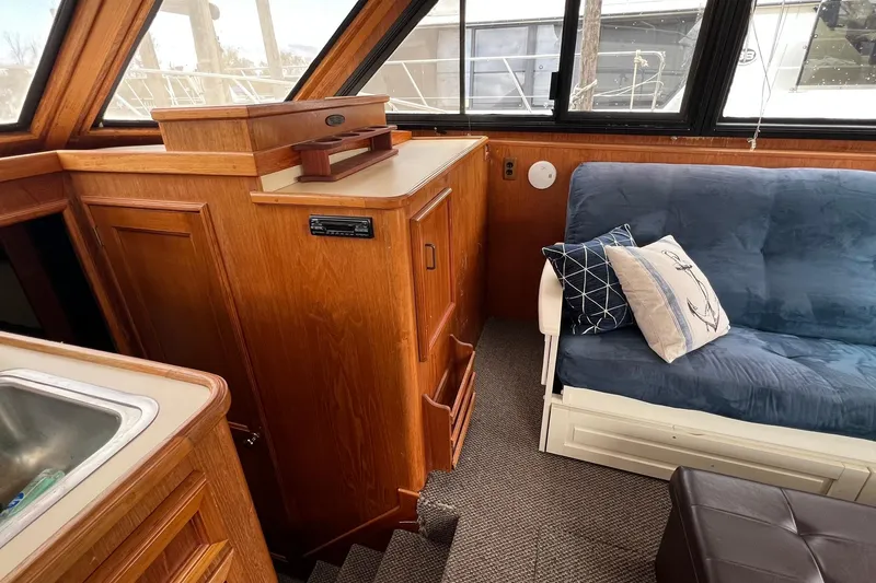 Slide: The Image of 1989 Egg Harbor 33 Convertible interior with wooden cabinetry and blue cushioned seating. - 33