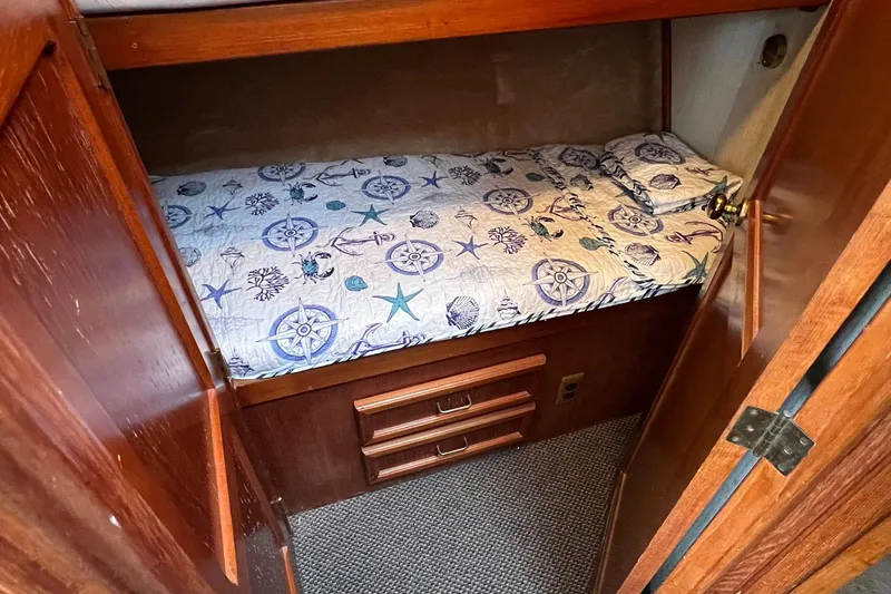 Slide: The Image of Cozy cabin bed in 1989 Egg Harbor 33 Convertible boat with nautical-themed bedding. - 35