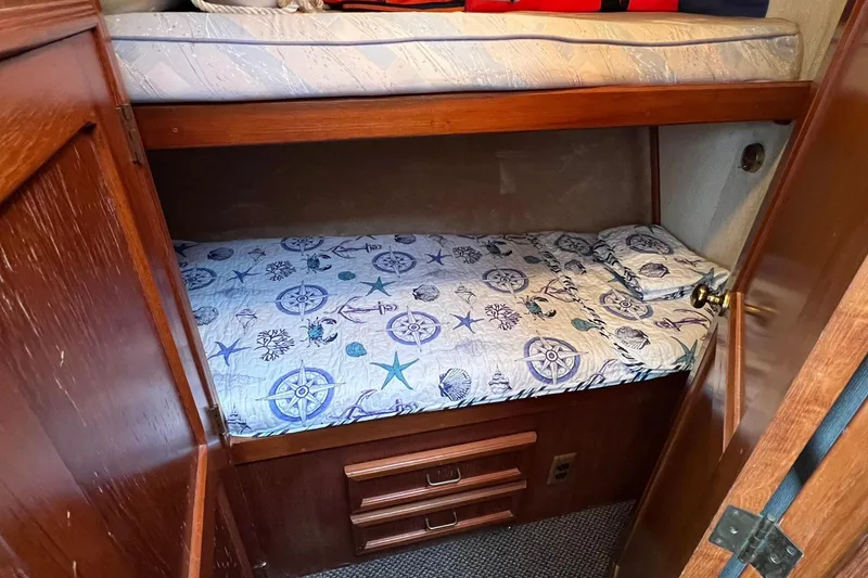 Slide: The Image of 1989 Egg Harbor 33 Convertible cabin with nautical-themed bedding and wooden cabinetry. - 37