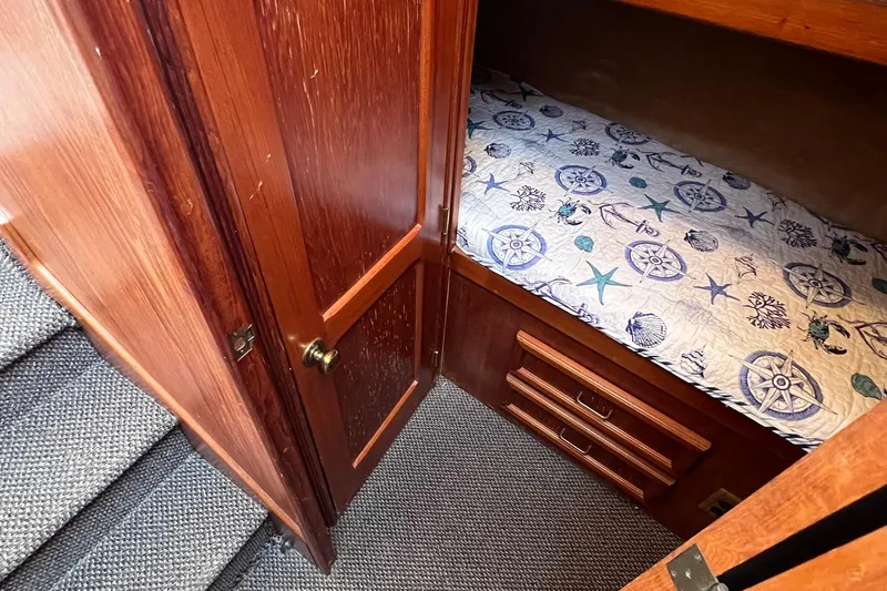 Slide: The Image of 1989 Egg Harbor 33 Convertible cabin with nautical-themed bedding and wooden cabinetry. - 38