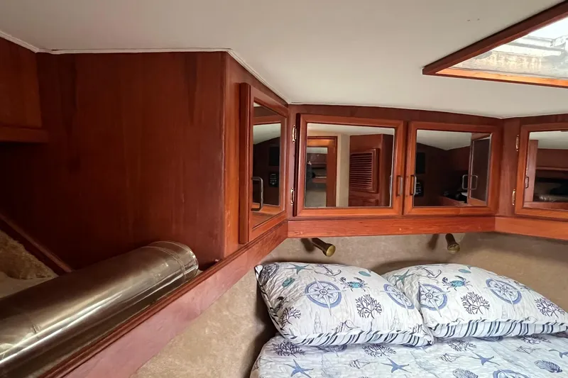 Slide: The Image of 1989 Egg Harbor 33 Convertible cabin with nautical-themed bedding and wooden cabinetry. - 41