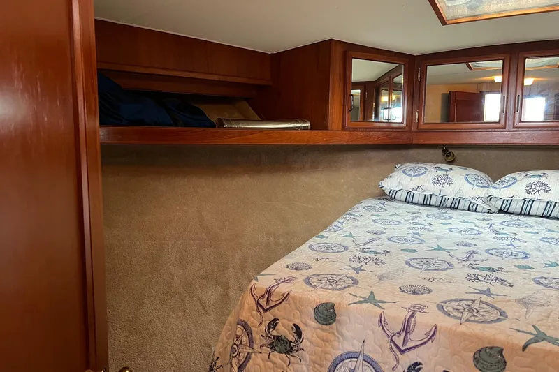 Slide: The Image of 1989 Egg Harbor 33 Convertible cabin with nautical-themed bedding and wooden cabinetry. - 44