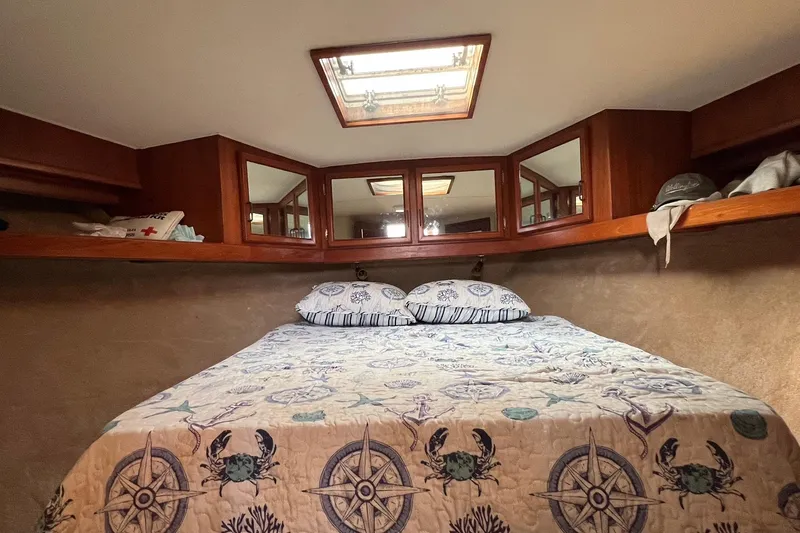 Slide: The Image of Cozy cabin interior of 1989 Egg Harbor 33 Convertible with nautical-themed bedding. - 8