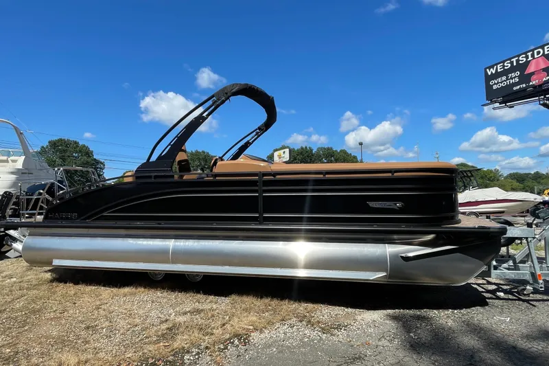 The Image of 2026 Harris Solstice 250 SLDH pontoon boat under clear blue sky. - 1