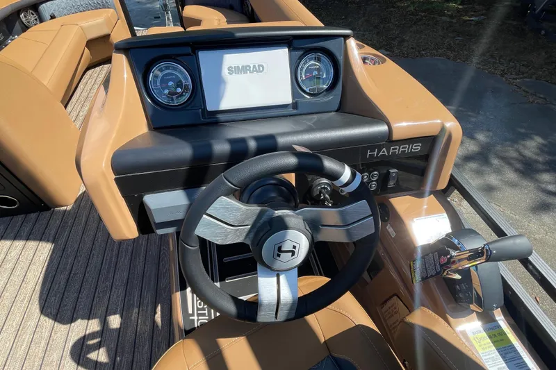 Slide: The Image of 2026 Harris Solstice 250 SLDH boat dashboard with steering wheel and Simrad display. - 10