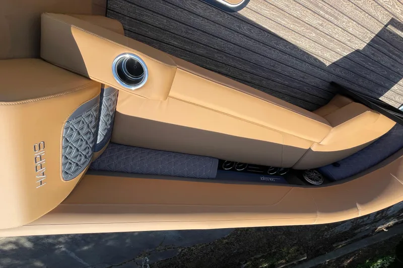 Slide: The Image of Luxurious seating on 2026 Harris Solstice 250 SLDH boat with tan upholstery and cup holder. - 12