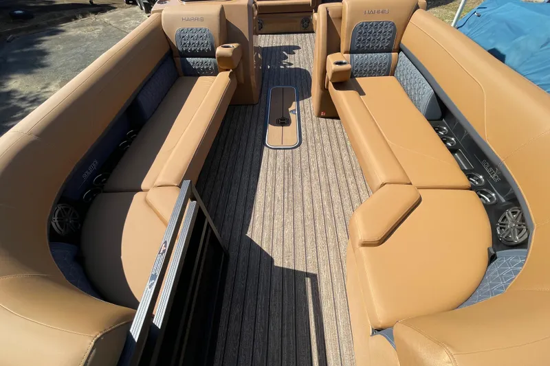 Slide: The Image of 2026 Harris Solstice 250 SLDH boat interior with tan seating and wood-style flooring. - 14
