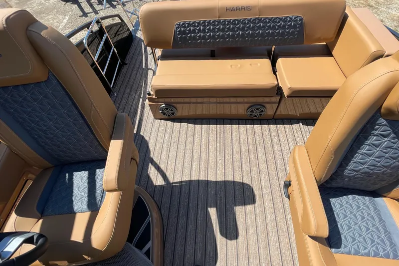 Slide: The Image of 2026 Harris Solstice 250 SLDH boat interior with tan and blue seating, textured flooring. - 9