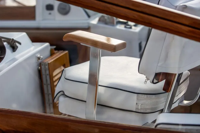 Slide: The Image of Captain's chair on 1994 Little Harbor Express boat, featuring wooden armrest and white cushion. - 23