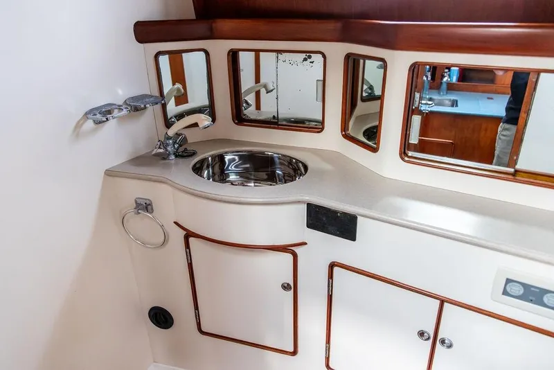 Slide: The Image of 1994 Little Harbor Express yacht bathroom with sink, mirrors, and storage cabinets. - 27