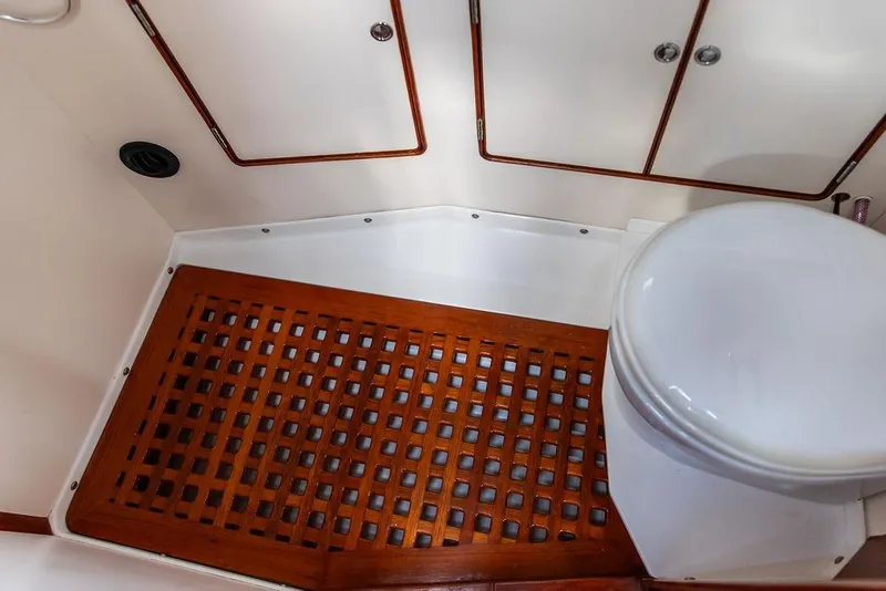 Slide: The Image of 1994 Little Harbor Express boat bathroom with wooden floor grate and white toilet. - 28