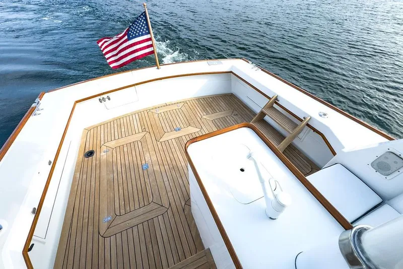 Slide: The Image of 1994 Little Harbor Express boat deck with American flag, wooden flooring, and ocean view. - 3