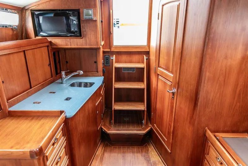 Slide: The Image of 1994 Little Harbor Express yacht interior with wooden cabinetry and compact kitchen area. - 33