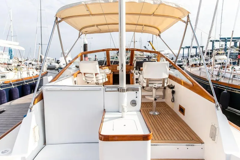 Slide: The Image of 1994 Little Harbor Express yacht interior with helm, seating, and canopy in marina setting. - 4