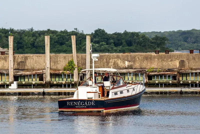 Slide: The Image of 1994 Little Harbor Express boat named "Renegade" on calm water near a dock. - 47