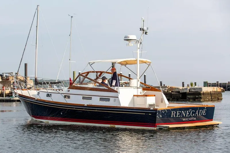 Slide: The Image of 1994 Little Harbor Express boat "Renegade" on water near dock, clear sky background. - 56